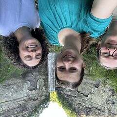 Three smiling people standing in front of Taughannock waterfall